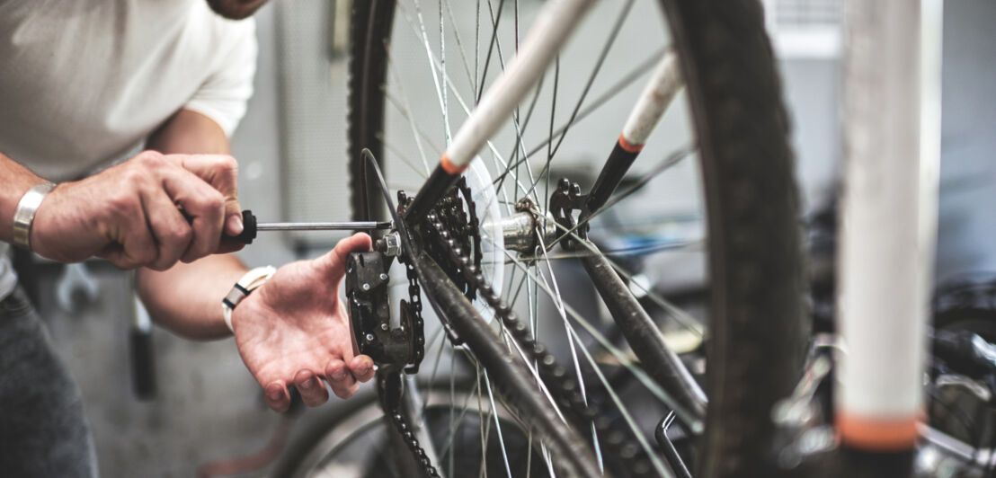 Mechaniker schraubt an Fahrrad