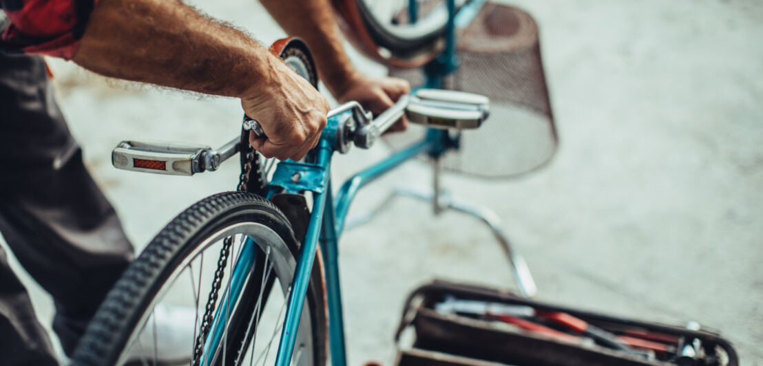 Mann arbeitet an Tretlager eines Fahrrads