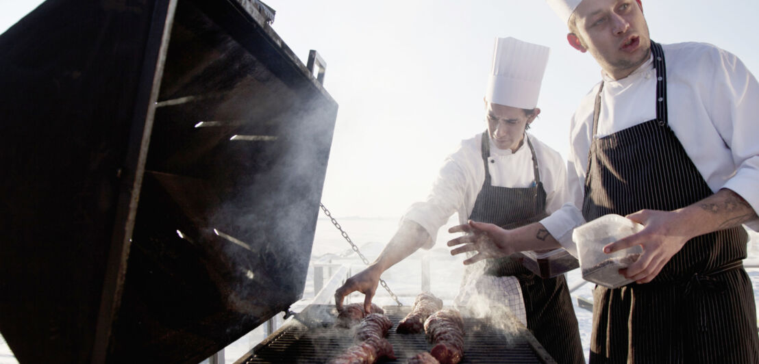 Zwei Männer stehen vor einem großen Grill