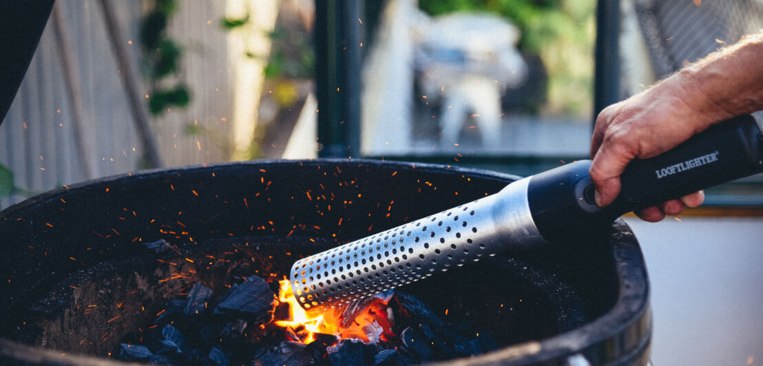 Ein Grillfön entzündet Holzkohle in einem Grill