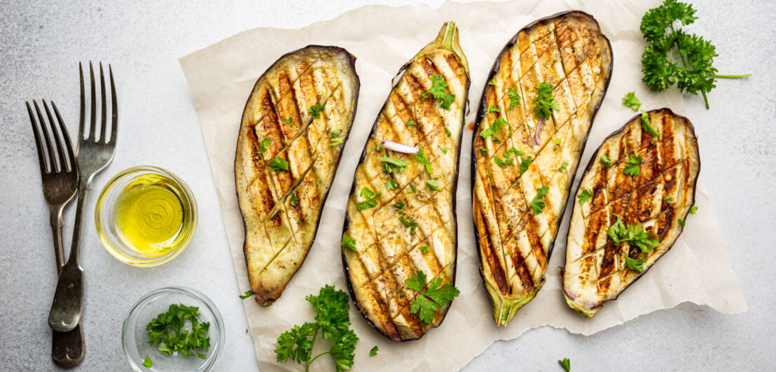 Gegrillte Aubergine liegen auf einem Stück Papier