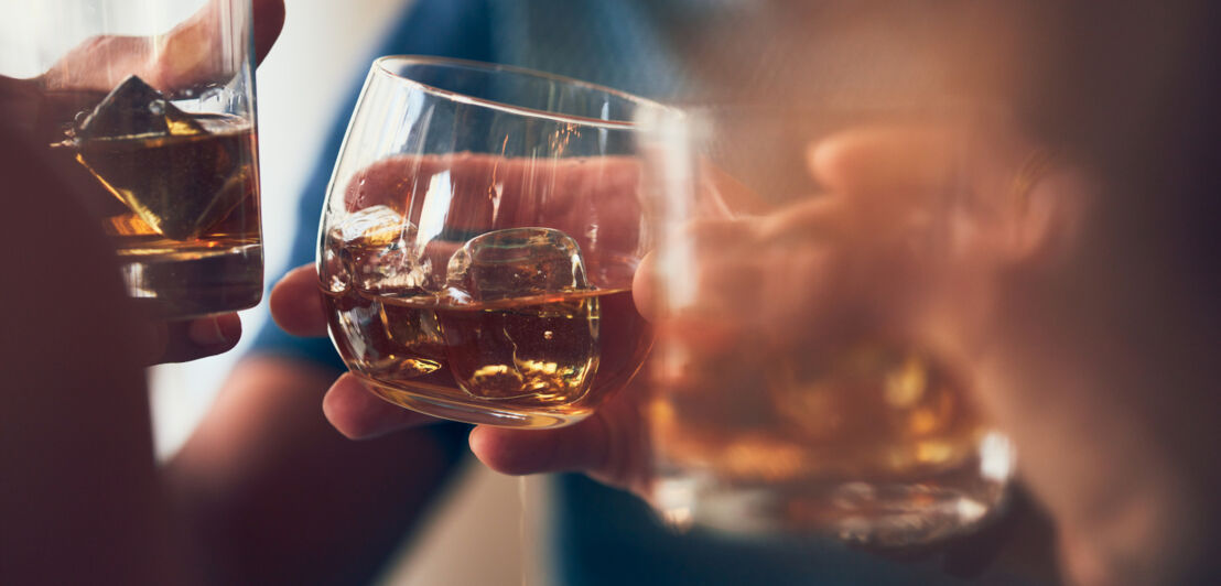 Drei Whisky auf Eis, mit denen angestoßen wird