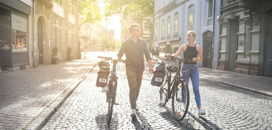 Zwei Fahrradfahrer:innen mit einem Rad-Trolley