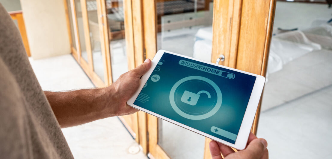 Ein Mann schaut sich Smart-Home-Software auf dem Tablet an