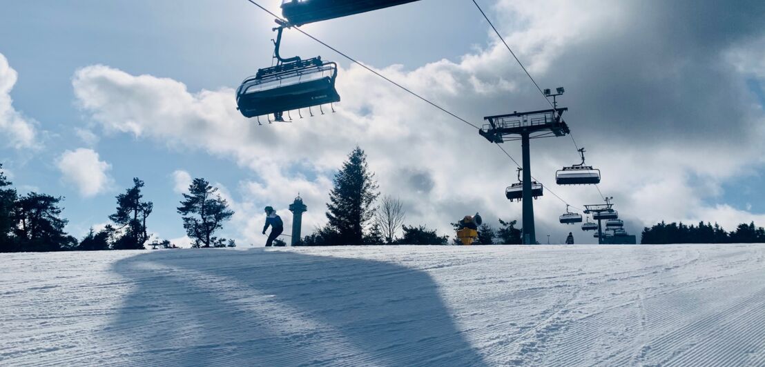 Eine verschneite Piste im Sauerland mit einer 8er-Gondel-Seilbahn