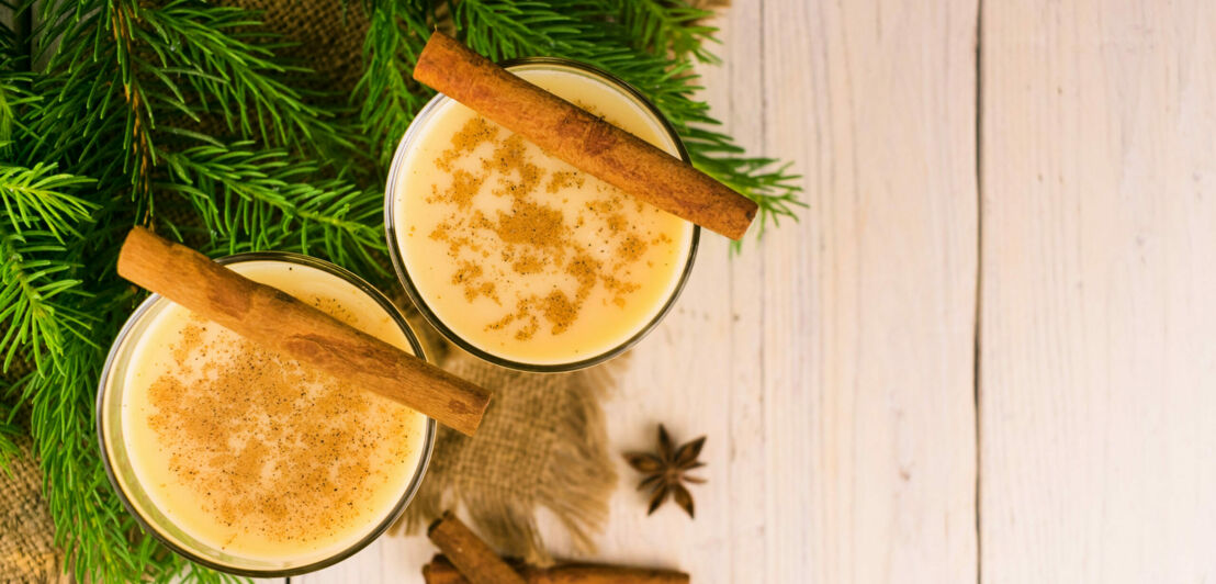 Zwei Gläser mit Glüh-Kaffee mit viel Milch und weihnachtlichen Gewürzen wie Zimtstangen und Anissternen