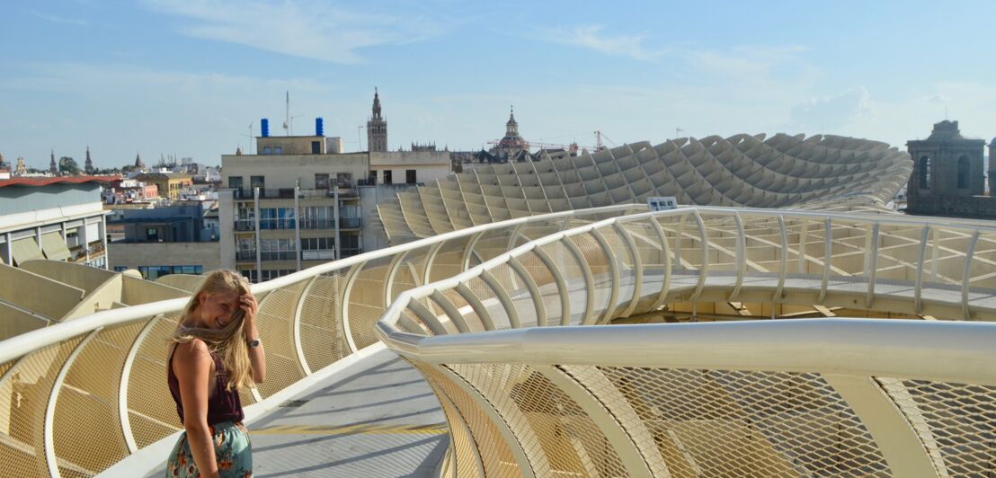 Eine junge Frau steht auf dem Metropol Parasol in Sevilla