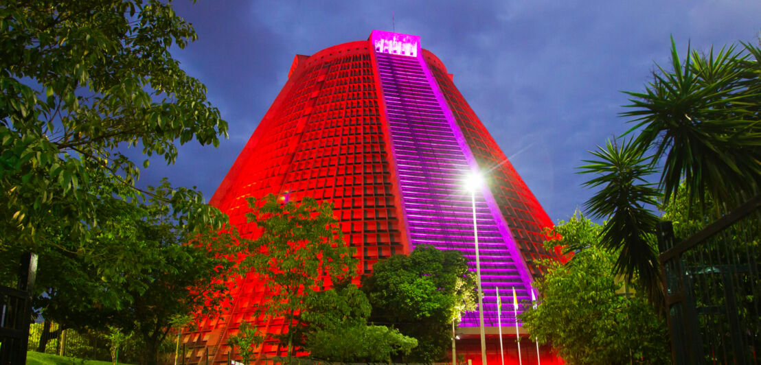 Die Kathedrale von Rio de Janeiro in Pyramidenform mit nächtlicher Außenbeleuchtung in den Farben Rot und Magenta