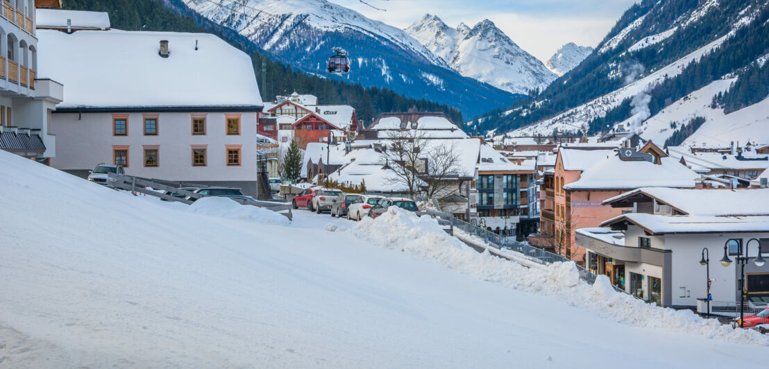 Schneebedeckte Häuser, im Hintergrund Berge