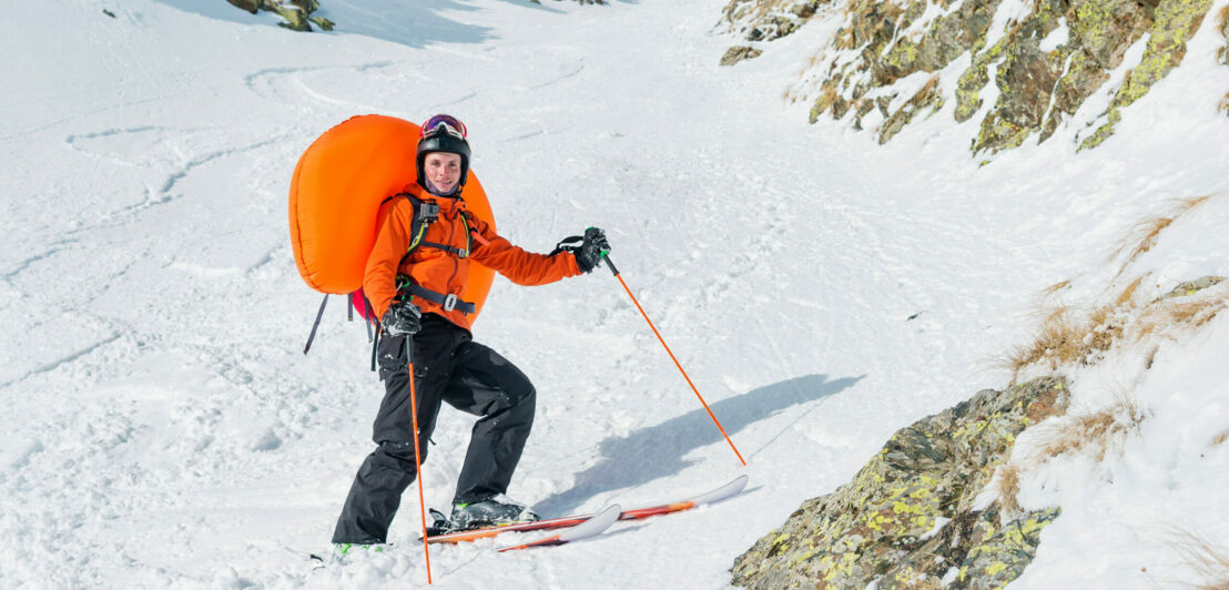 Ein Freerider mit einem geöffneten Lawinenrucksack.