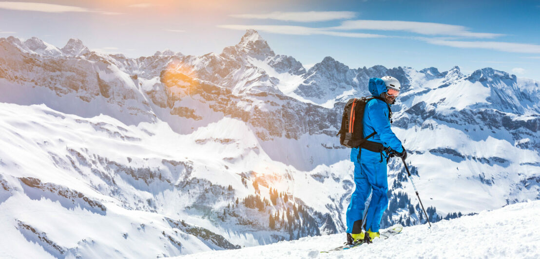 Ein Skiläufer vor schneebedeckten Gipfeln.