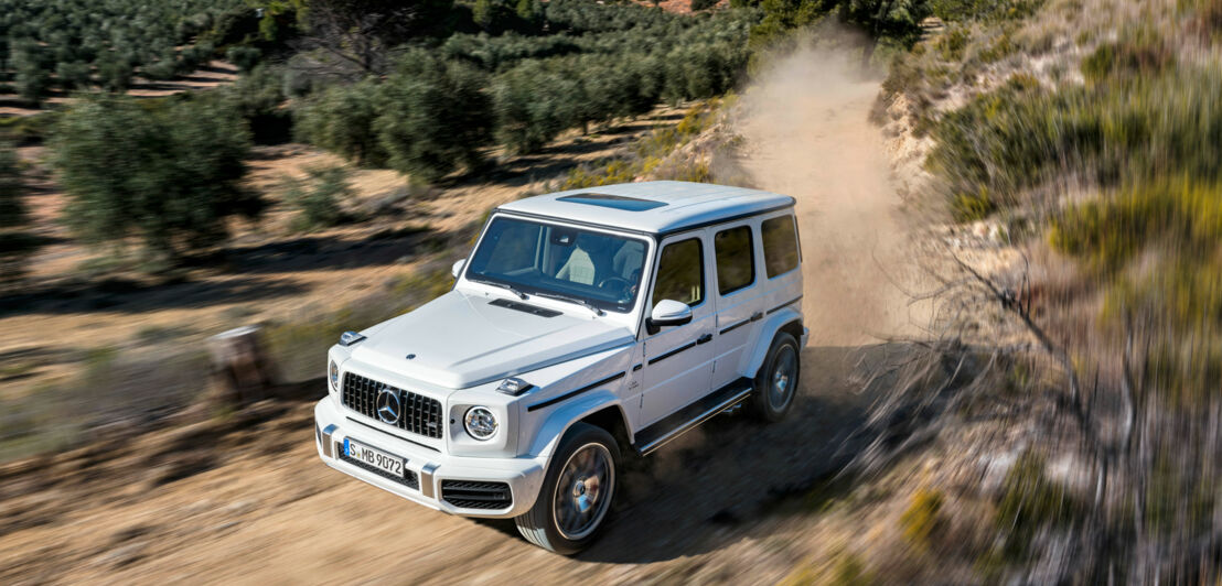 Ein Mercedes G 63 AMG fährt durchs Gelände.