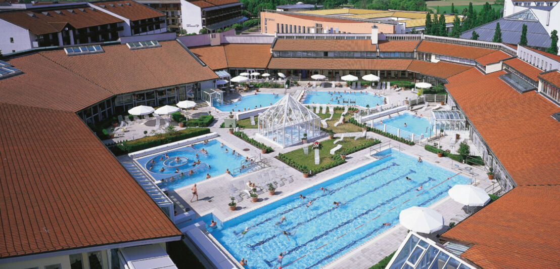 Panoramablick auf eine großflächigen Poollandschaft im Außenbereich einer Badeanstalt