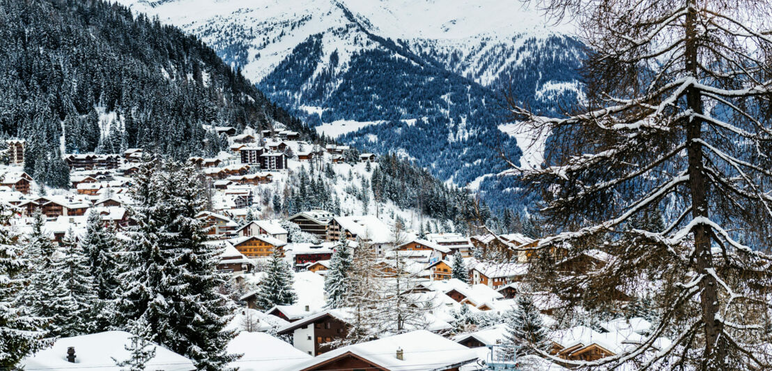 Eine verschneite kleine Stadt vor einer Bergkulisse