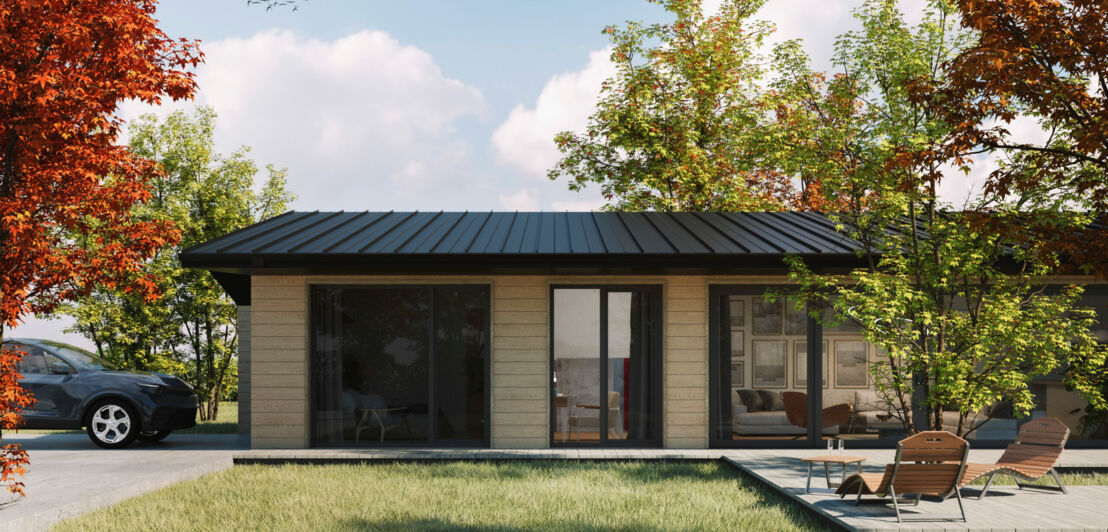 Ein moderner Bungalow aus Holz mit bodentiefen Fenstern, umgeben von Natur