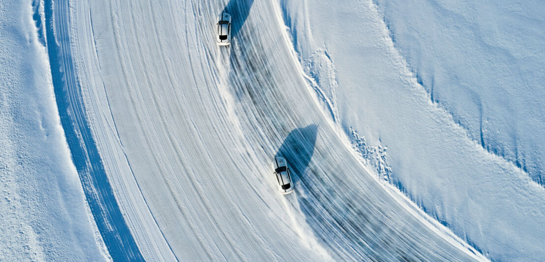 Zwei Fahrzeuge driften über einen zugefrorenen See in Schweden