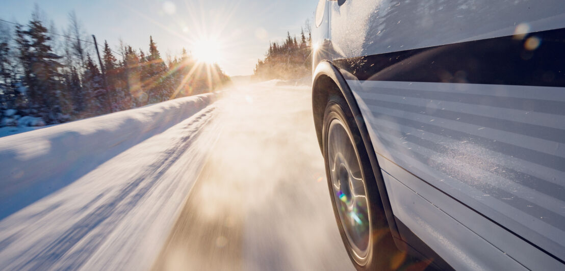 Ein Porsche fährt über eine mit Schnee bedeckte Straße