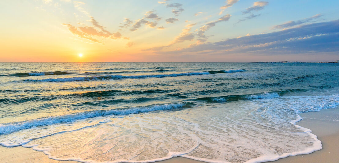 Ein Strand, an dem kleine Wellen ankommen