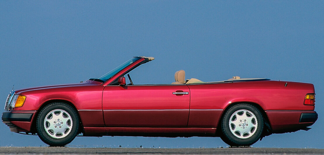 Ein rotes Mercedes-Cabriolet der Baureihe W 124 von der Seite