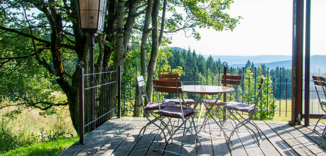 Die Terrasse eines Biergartens auf einem Berg, im Hintergrund weitläufige Landschaft