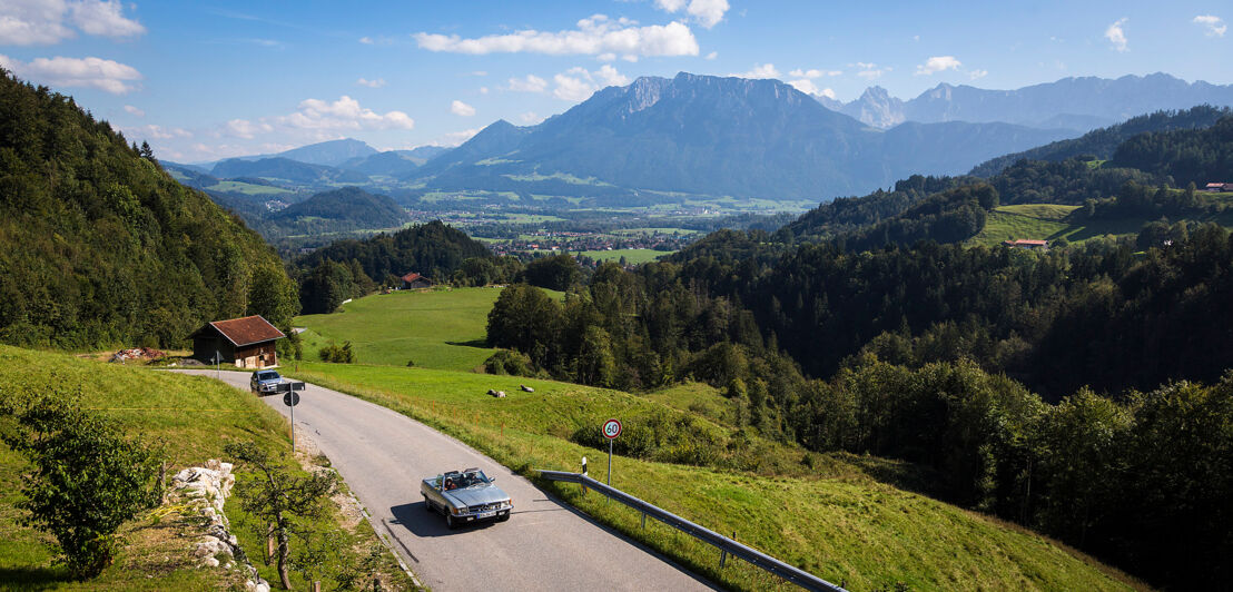 Ein Cabriolet auf einer Straße in den Alpen.