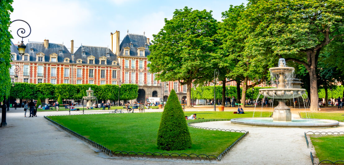 Geometrisch angelegte Wege und ein Springbrunnen auf dem Place des Vosges.