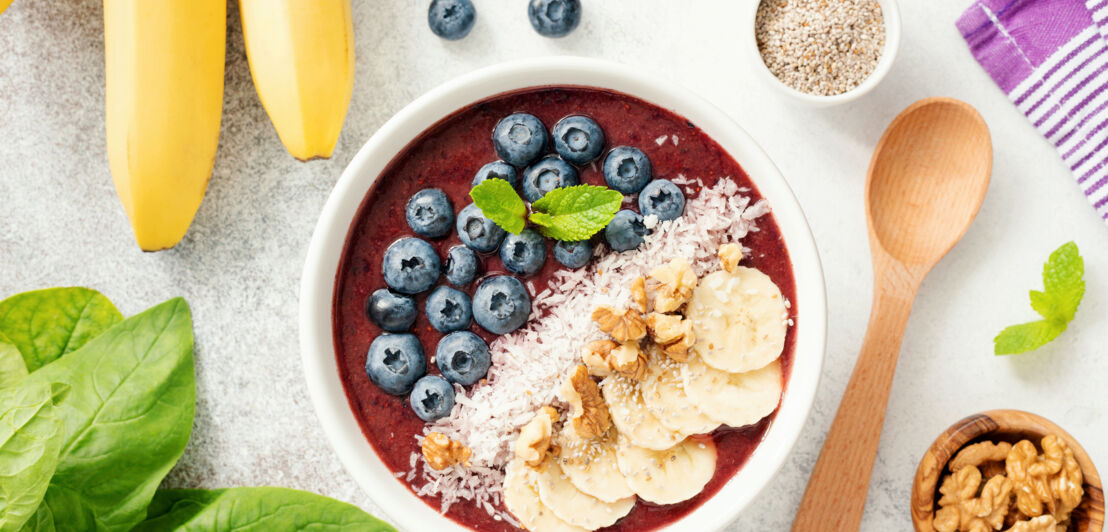 Eine Schale mit frischen Blaubeeren, Bananenscheiben und Walnüssen.