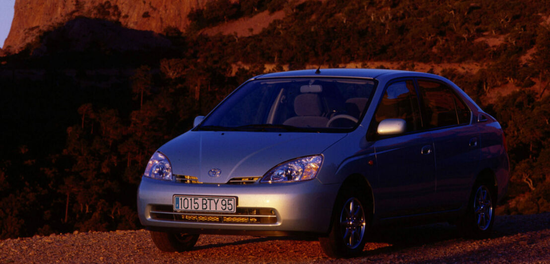 Ein silbernes Auto vor roten Felsen