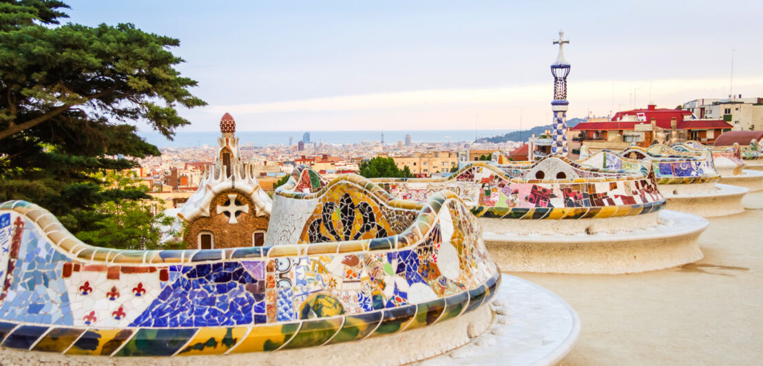 Geschwungene, mosaikbesetzte Bank im Park Güell mit Blick über Barcelona