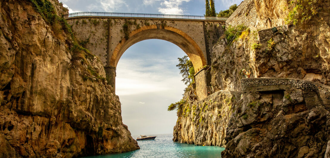 Eine Steinbrücke führt über eine Schlucht.