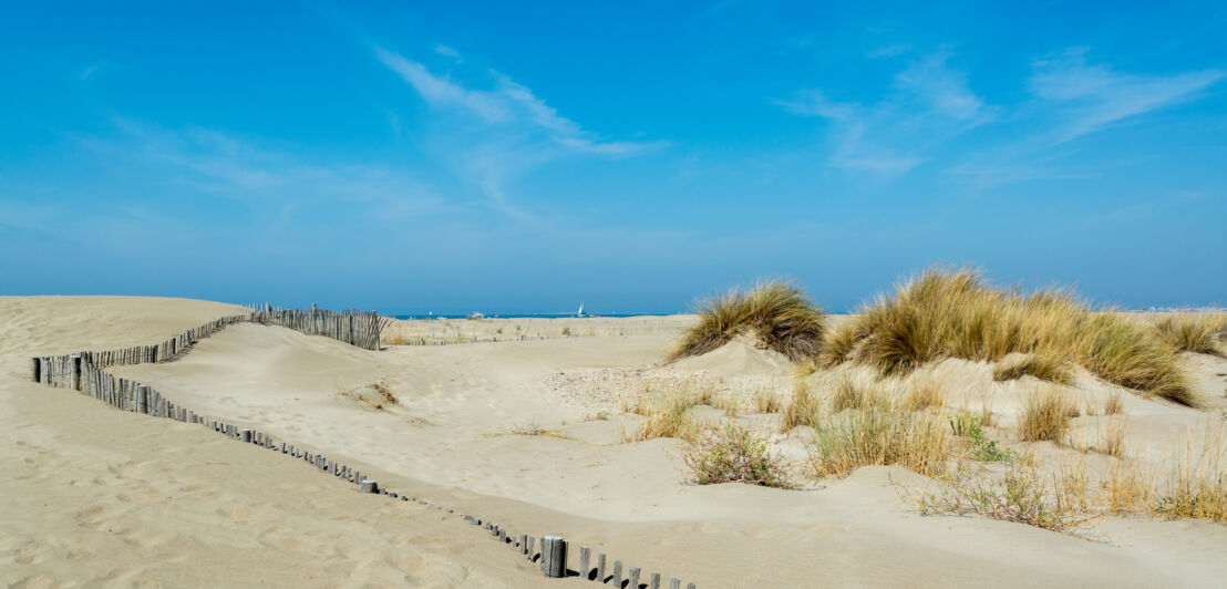 Schöner weißer Sandstrand mit Dünengras und blauem Himmel