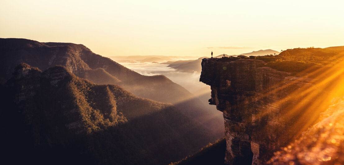 Eine Gebirgslandschaft mit Gipfel, die über Nebel hinausragen