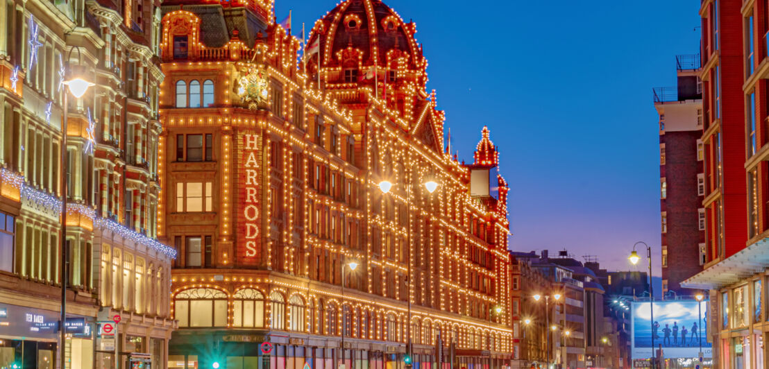 Außenansicht des Kaufhauses Harrods in London mit beleuchteter Fassade bei Nacht