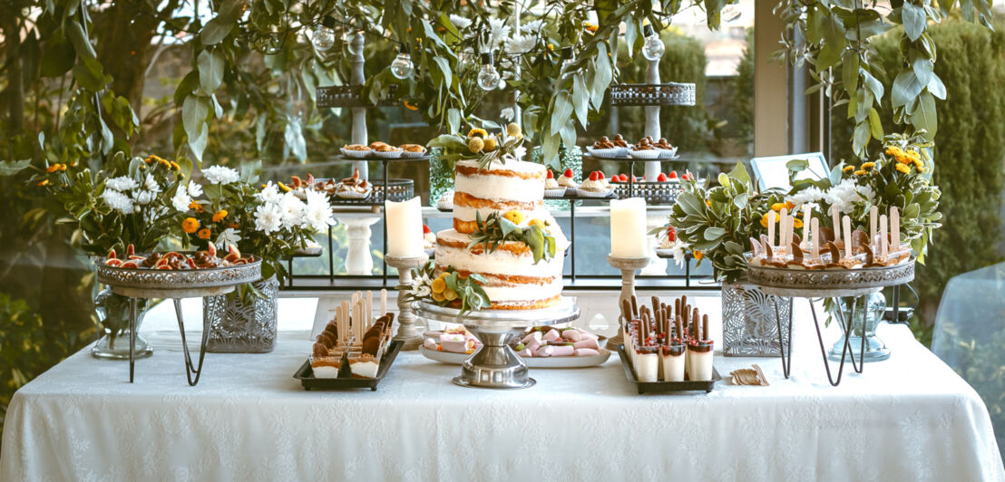 Eine Candy Bar mit einem Naked Cake in der Mitte und kleinen Dessertschälchen drumherum