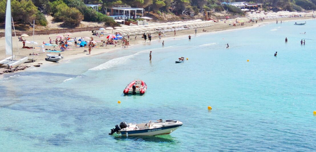 Ein Strand mit Booten im türkisblauen Wasser