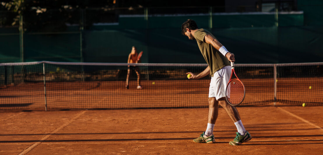 Pärchen beim Tennisspiel auf einem Sandplatz