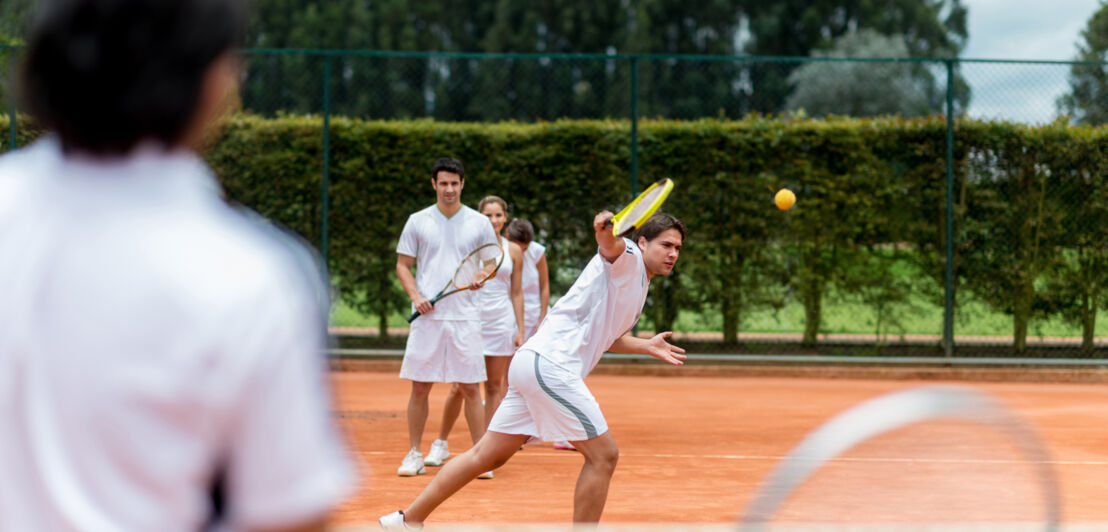 Gruppe von Personen, die Tennisunterricht nehmen