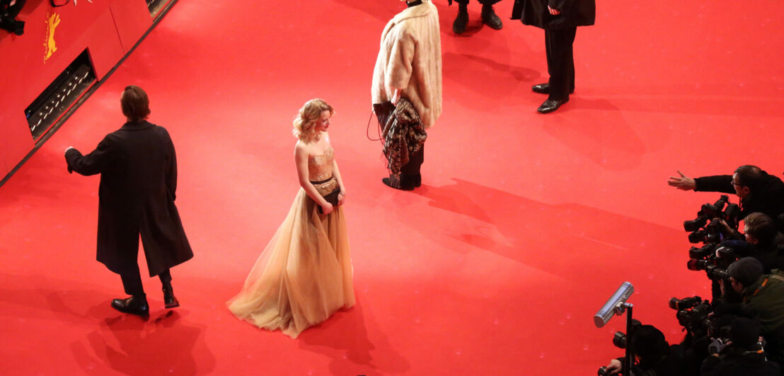 Zwei glamourös gekleidete Schauspielerinnen auf dem roten Teppich der Berlinale, umgeben von Pressefotografen