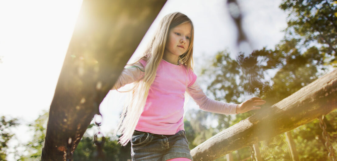 Ein Mädchen spielt auf einem Outdoor-Spielplatz