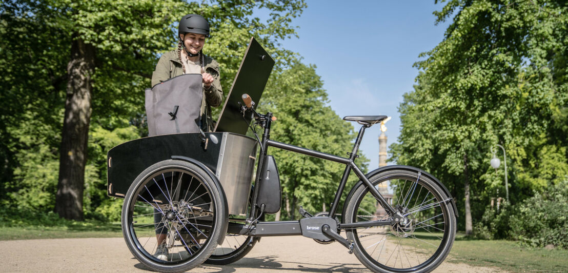 Eine Radfahrerin an einem Lastenrad