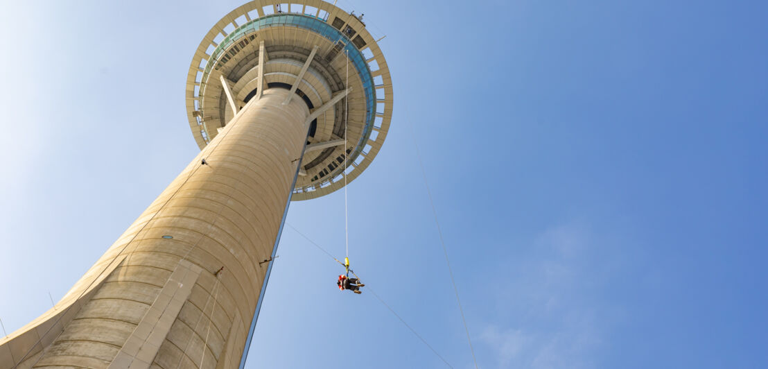 Eine Person macht einen Bungeesprung von einem Turm.