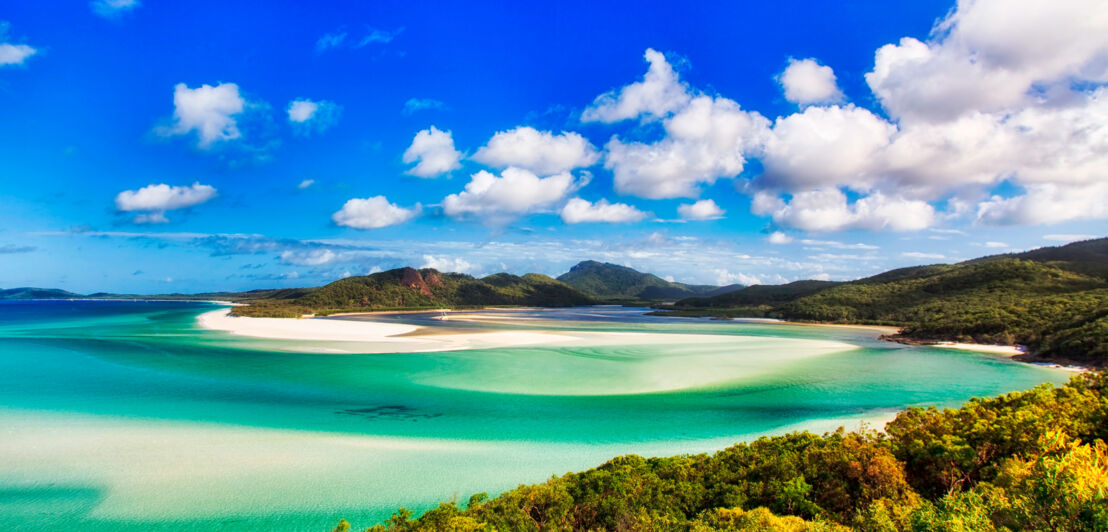 Landschaft mit Strand, Meer, Hügeln und Bäumen