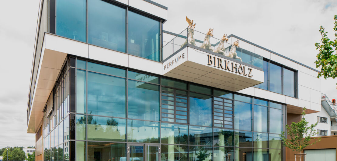 Kubistisches Glasgebäude der Firma Birkholz mit Quadriga auf der Terrasse