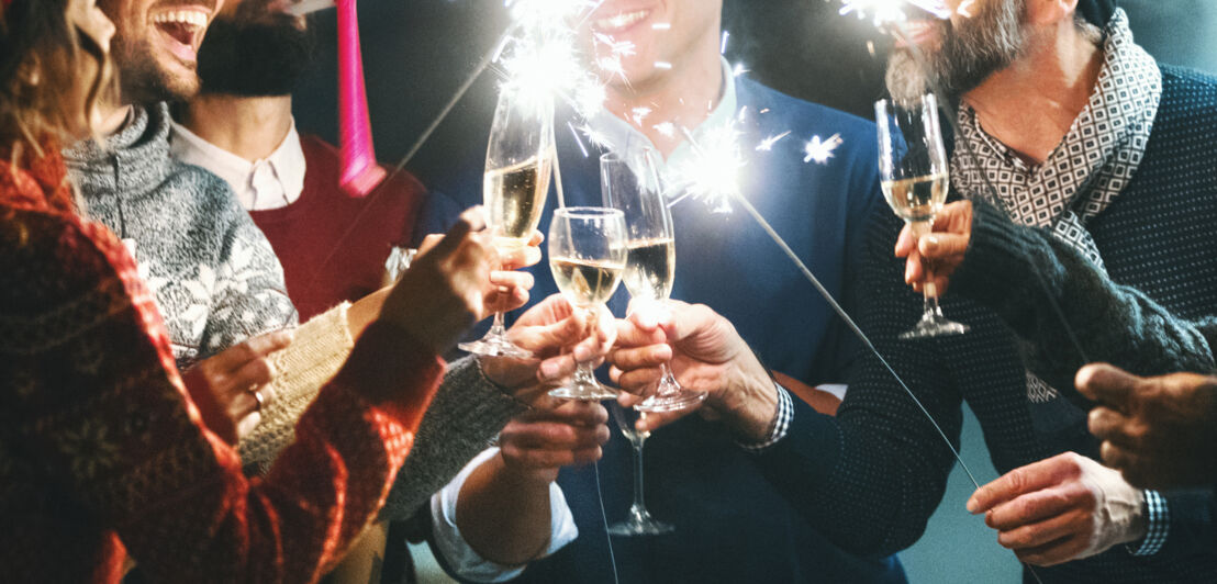 Freunde stoßen zu Silvester mit Sekt an