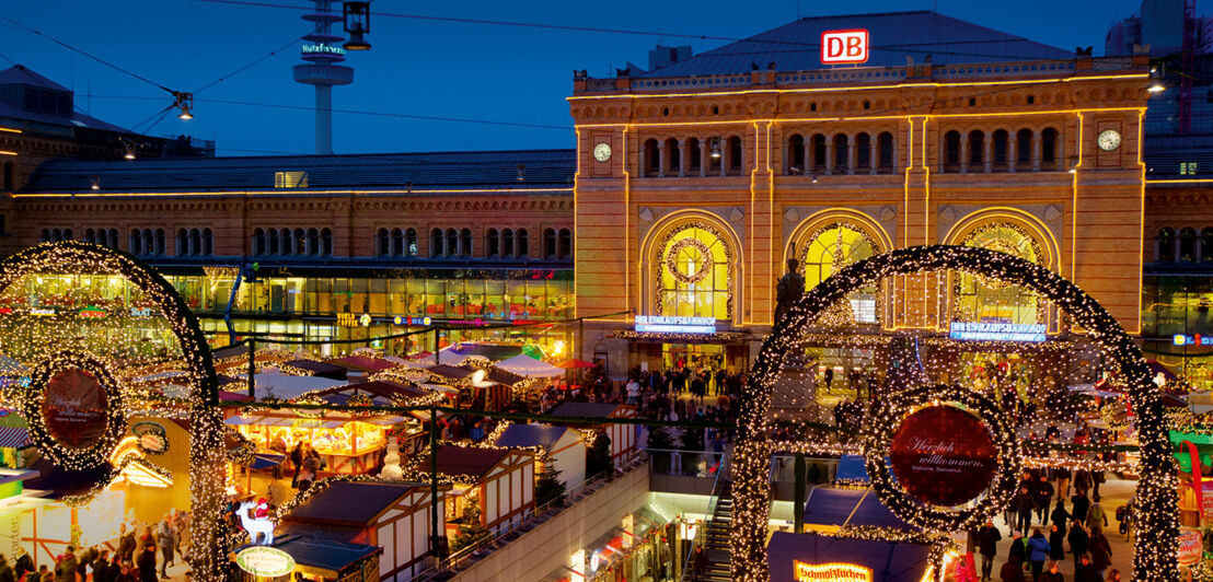 Weihnachtlich geschmückter Bahnhof mit Buden davor