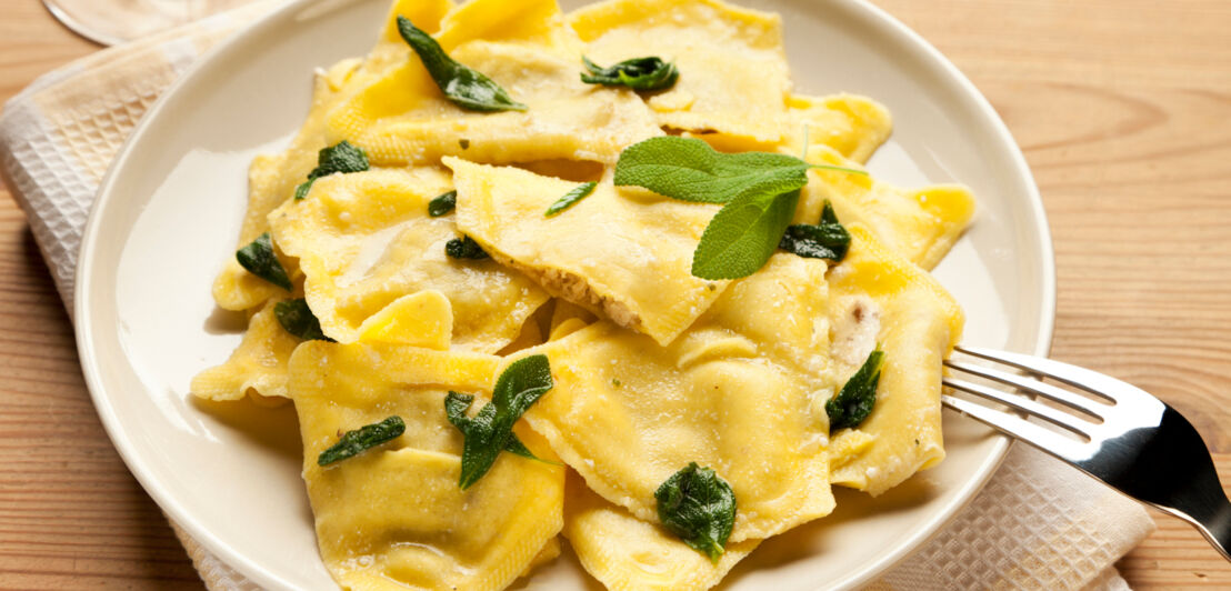 Ravioli mit frischen Kräutern auf einem weißen Teller