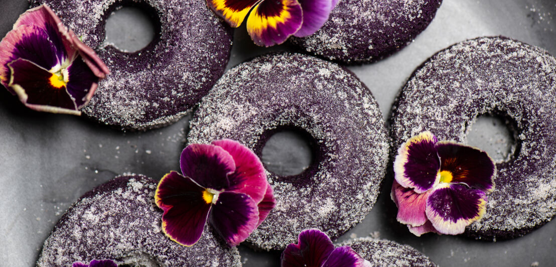 Lila Yamswurzel in Donutform, mit Blumen dekoriert