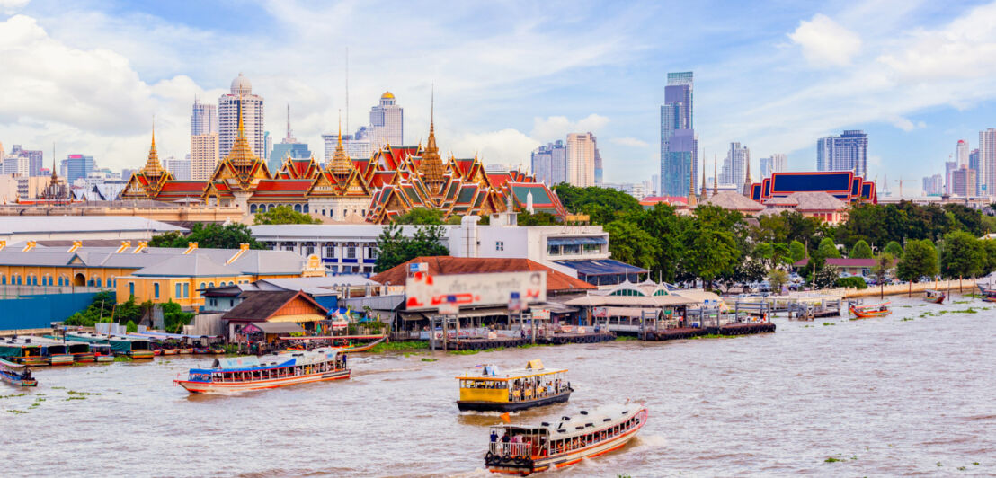 Der Fluss Chao Phraya auf dem Schiffe unterwegs sind, im Hintergrund ist die Skyline von Bangkok zu sehen