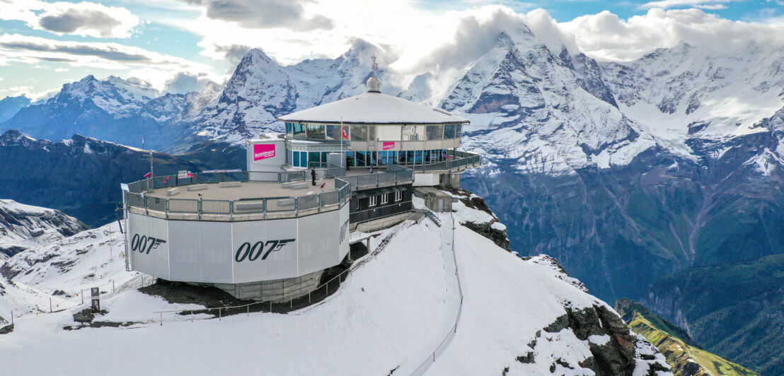 Blick auf das Restaurant Piz Gloria vor einer Bergkulisse