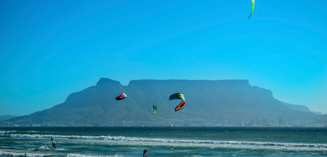 Kitesurfer im Meer, im Hintergrund Kapstadt am Fuße des Tafelbergs